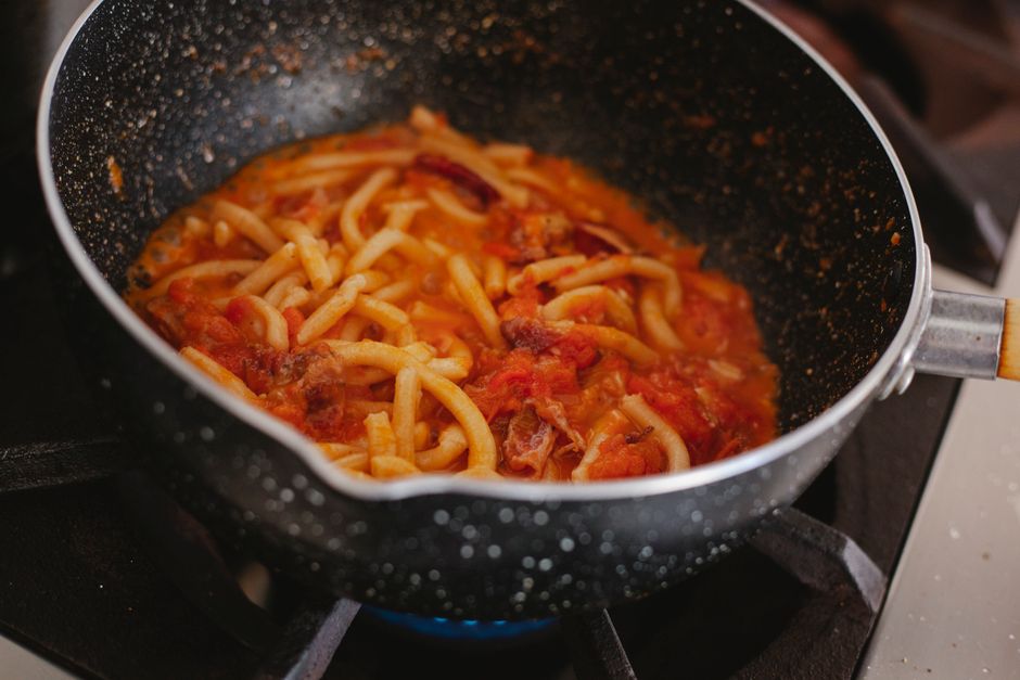 Plum tkemali sauce simmering in a pot on the stove