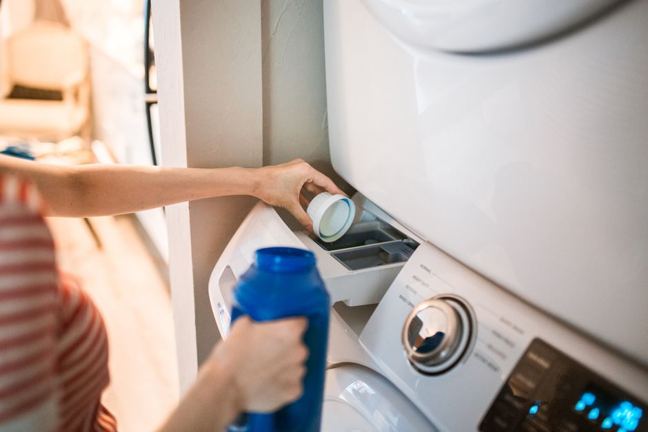 Liquid detergent being poured into the washing machine dispenser drawer
