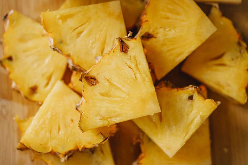 Нарезанный кубиками ананас на деревянной доске